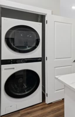 A full-size stacked washer and dryer in the laundry closet of a Pointe Grand apartment home