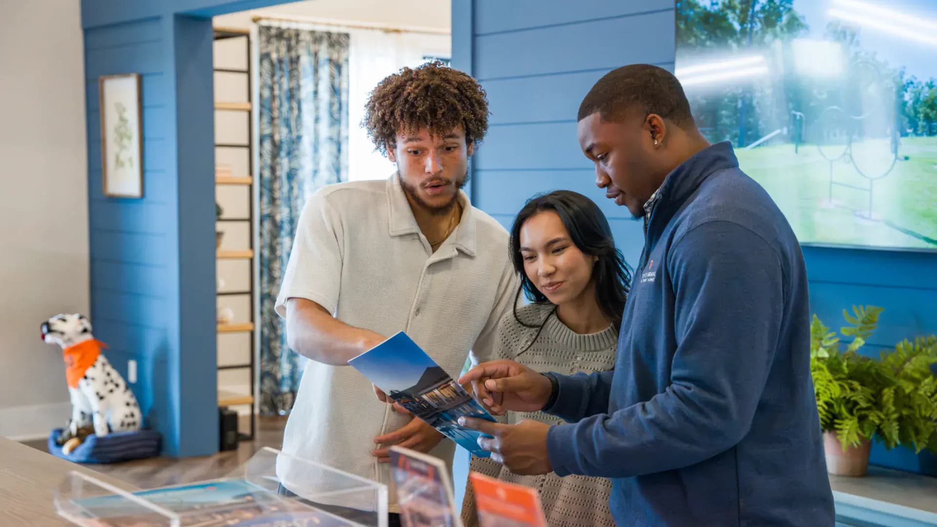 A Pointe Grand leasing team member going through a community brochure with two renters