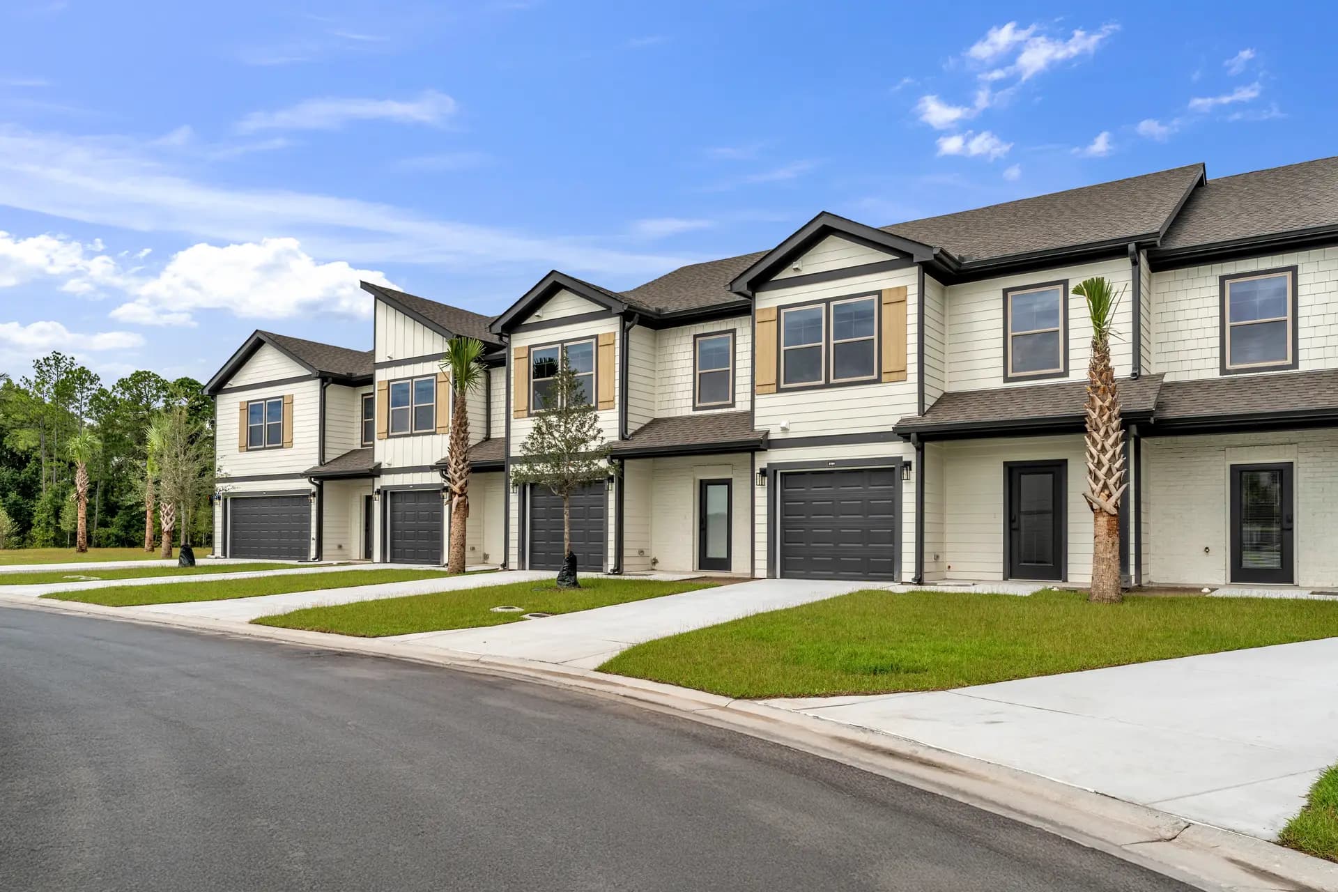 Bergen Woods townhomes with tan board-and-batten shutters along the community street