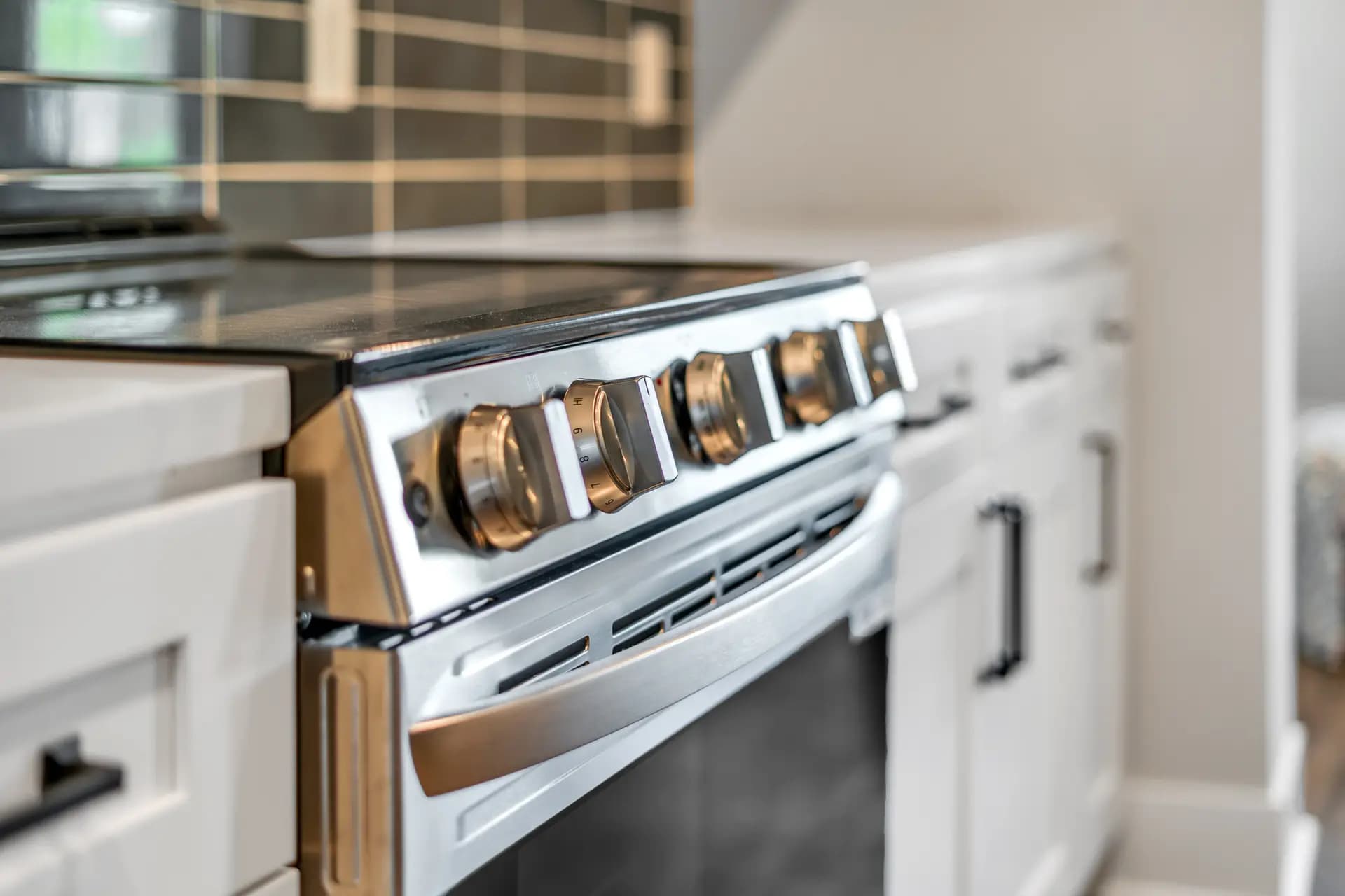 Stainless steel range against the teal subway tile backsplash