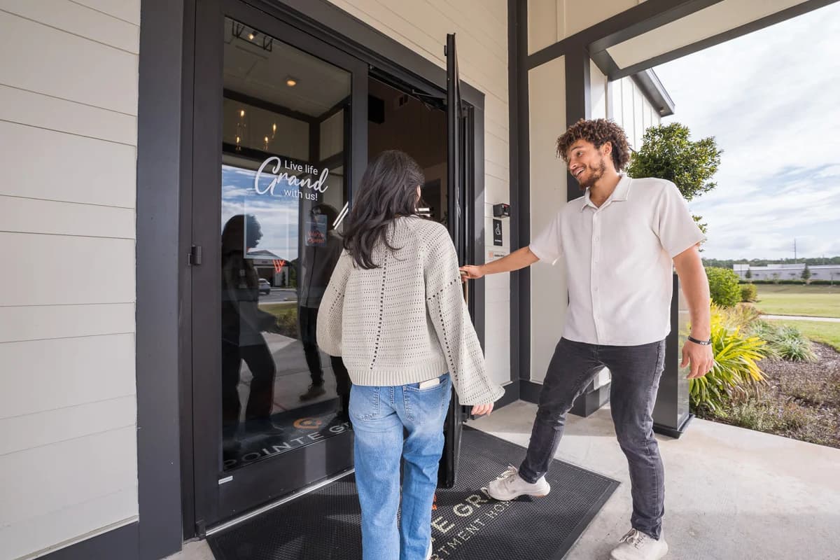 A couple being welcomed into a Pointe Grand leasing office